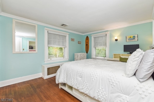 bedroom with radiator, crown molding, dark hardwood / wood-style flooring, and multiple windows