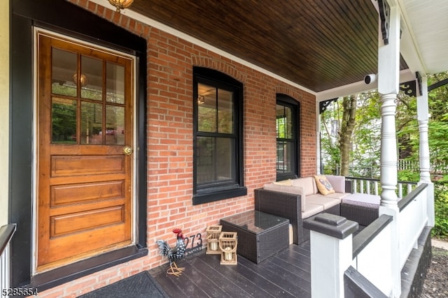 wooden terrace featuring an outdoor living space and a porch