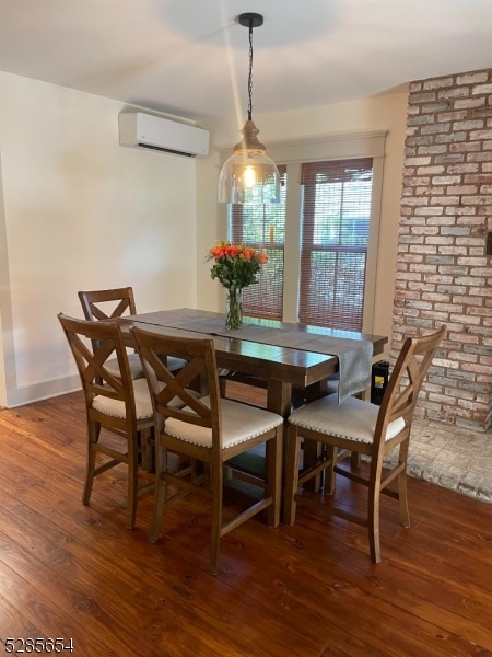 dining room with a wall mounted air conditioner and dark hardwood / wood-style floors