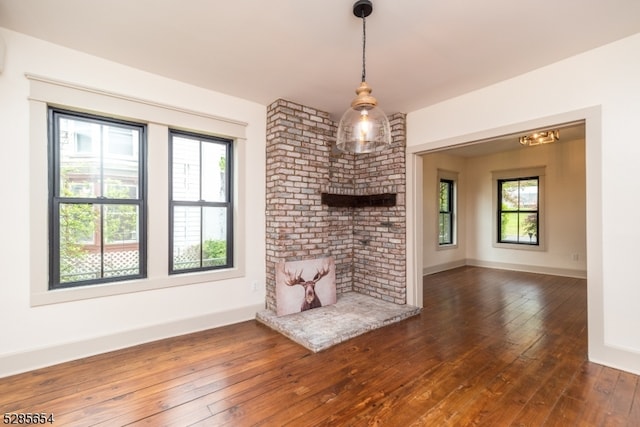 unfurnished living room with dark wood-type flooring and a wealth of natural light