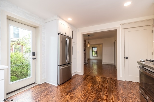 kitchen with dark hardwood / wood-style floors, appliances with stainless steel finishes, and white cabinetry