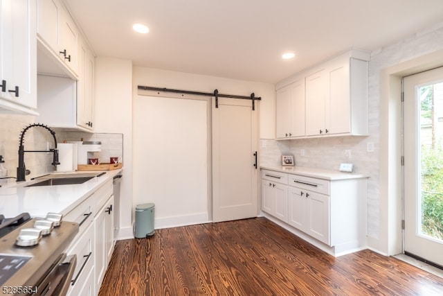 kitchen with a barn door, plenty of natural light, dark wood-type flooring, and white cabinetry