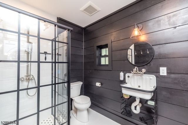 bathroom with wood walls, walk in shower, sink, and toilet