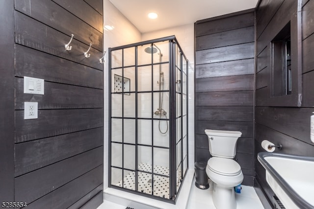 bathroom featuring a shower with shower door and toilet