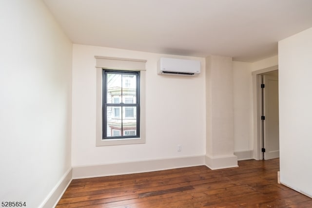 unfurnished room with dark wood-type flooring and a wall unit AC