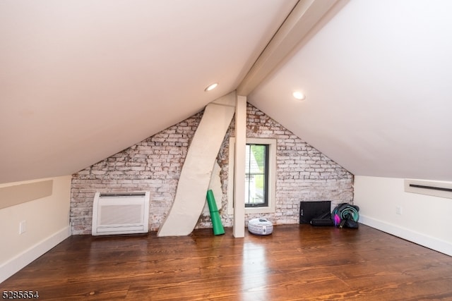 additional living space featuring vaulted ceiling with beams and dark wood-type flooring