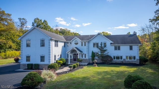 colonial inspired home with a front lawn