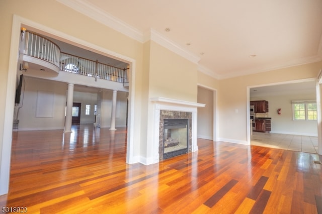 unfurnished living room featuring ornamental molding, hardwood / wood-style flooring, and decorative columns