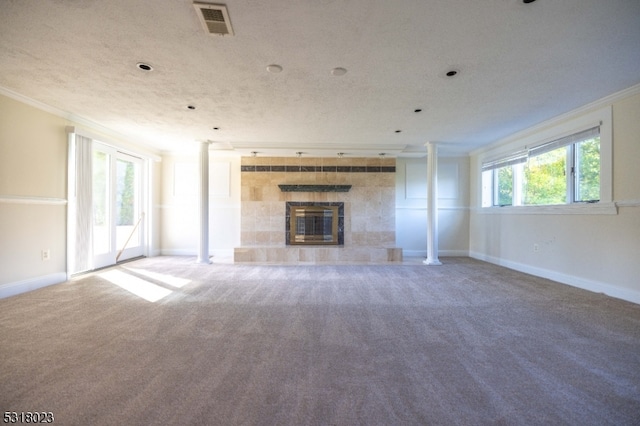 unfurnished living room featuring ornamental molding, a tiled fireplace, carpet floors, and a textured ceiling