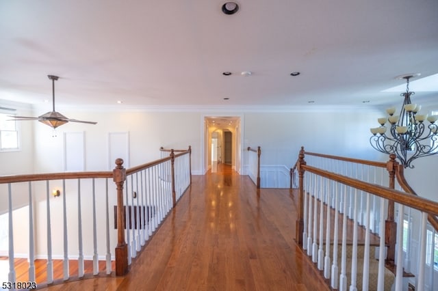 corridor with an inviting chandelier, dark hardwood / wood-style floors, and crown molding