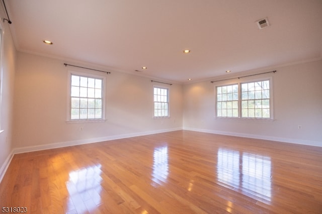 empty room featuring crown molding and light hardwood / wood-style floors