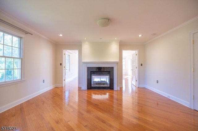 unfurnished living room with crown molding and light hardwood / wood-style flooring