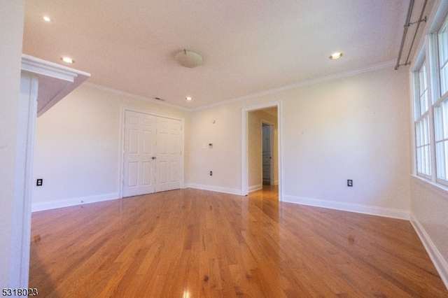 spare room with hardwood / wood-style flooring and crown molding