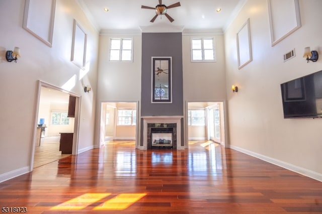 unfurnished living room featuring ornamental molding, hardwood / wood-style flooring, and a wealth of natural light