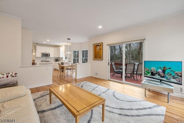 living room with recessed lighting, visible vents, baseboards, and light wood finished floors