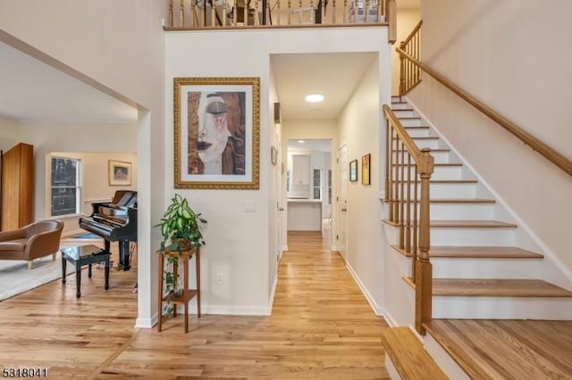 entrance foyer featuring stairway, light wood-style floors, and baseboards