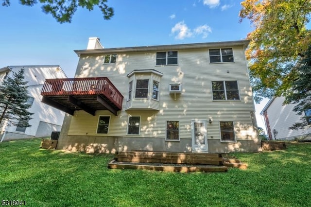 rear view of house with a wooden deck, a lawn, and a chimney