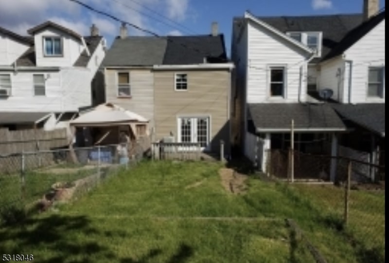 rear view of house featuring a gazebo and a yard