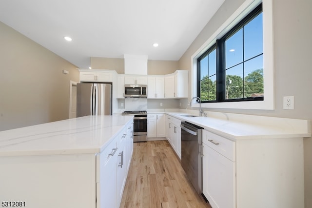 kitchen with light stone counters, white cabinetry, sink, and appliances with stainless steel finishes