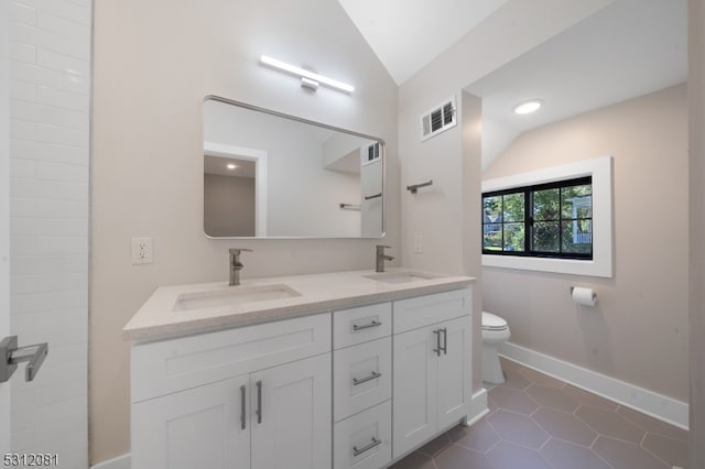 bathroom featuring tile patterned flooring, vanity, vaulted ceiling, and toilet