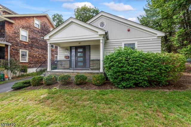 view of front of house featuring covered porch and a front yard