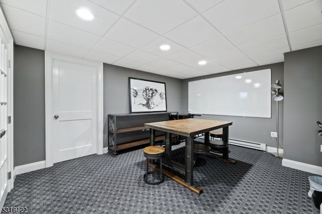 home office featuring dark carpet, baseboard heating, and a paneled ceiling