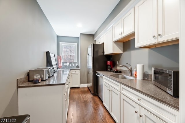 kitchen featuring stainless steel appliances, dark wood-type flooring, sink, and white cabinetry