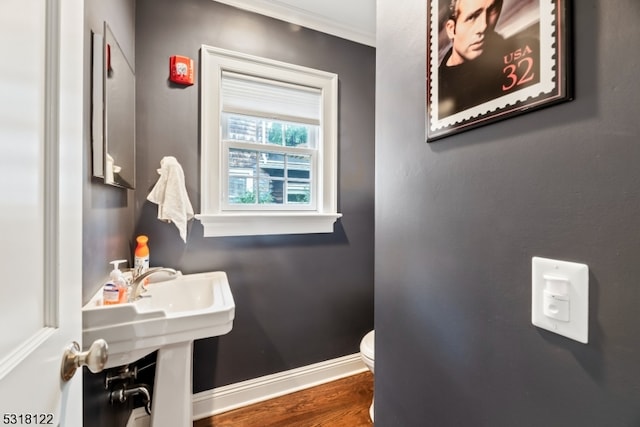 bathroom with ornamental molding, hardwood / wood-style flooring, and toilet