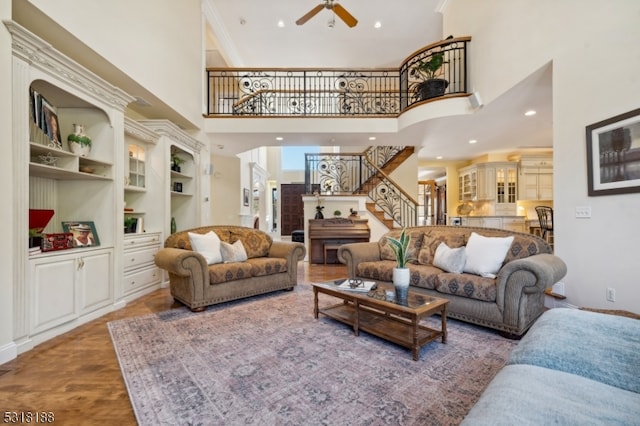 living room featuring a towering ceiling, hardwood / wood-style flooring, and ceiling fan