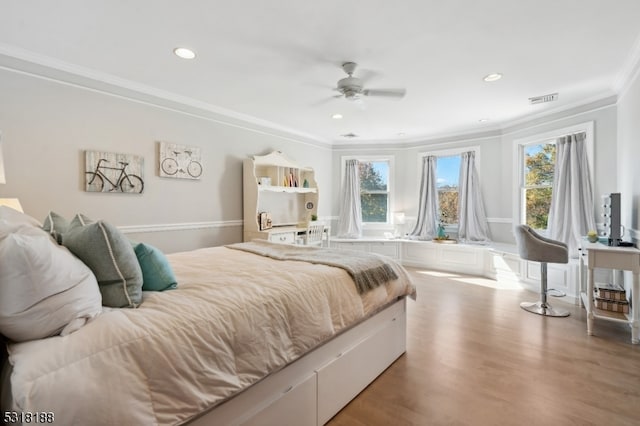 bedroom with ceiling fan, ornamental molding, multiple windows, and light hardwood / wood-style floors