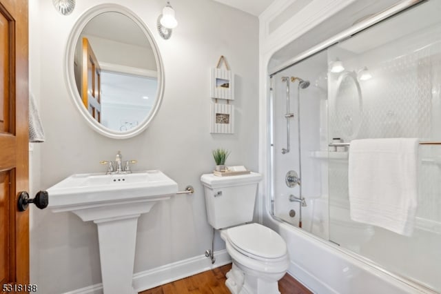 bathroom featuring toilet, bath / shower combo with glass door, and wood-type flooring