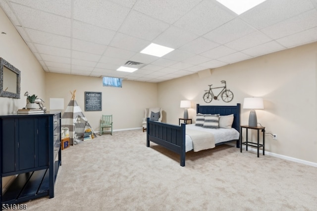 carpeted bedroom featuring a drop ceiling