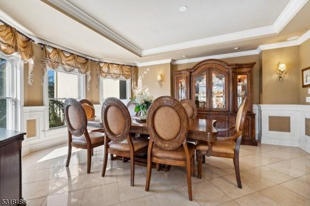 dining space featuring crown molding, a tray ceiling, and light tile patterned floors