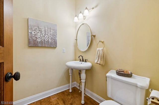 bathroom featuring hardwood / wood-style flooring and toilet