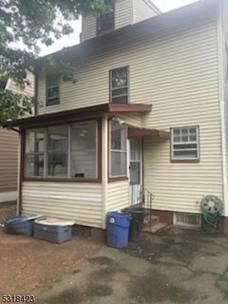 back of property with a sunroom