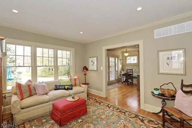 living area featuring crown molding, wood finished floors, and baseboards