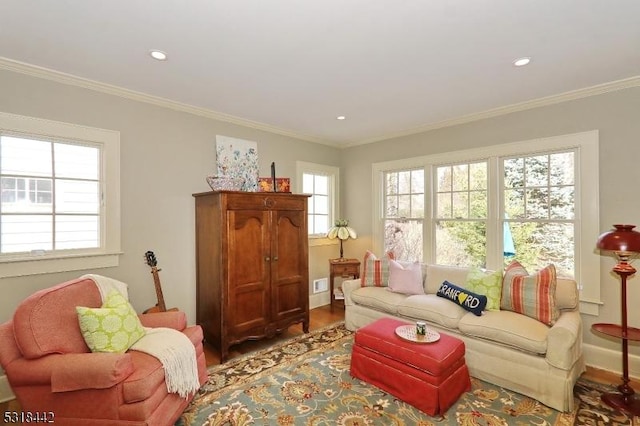 living room with wood finished floors, a healthy amount of sunlight, and ornamental molding