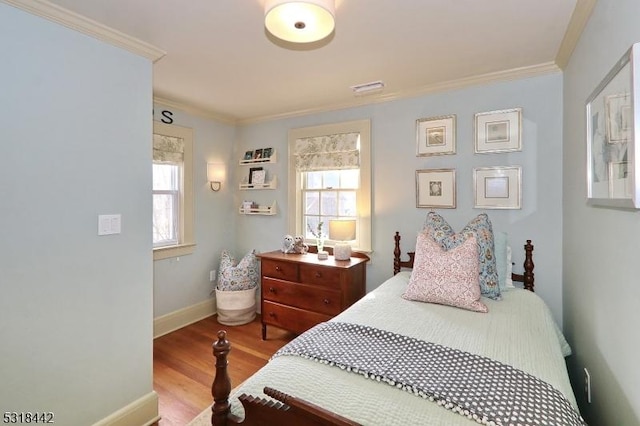 bedroom featuring crown molding, wood finished floors, and baseboards