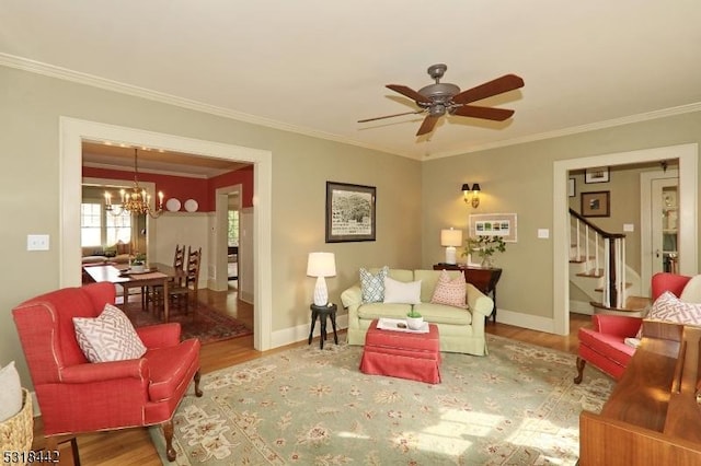 living area with wood finished floors, stairs, and ornamental molding