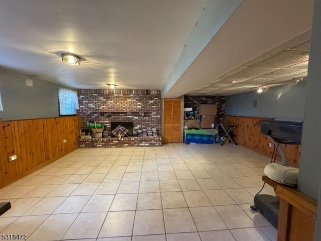 bar featuring a wainscoted wall, light tile patterned floors, a fireplace, and wooden walls