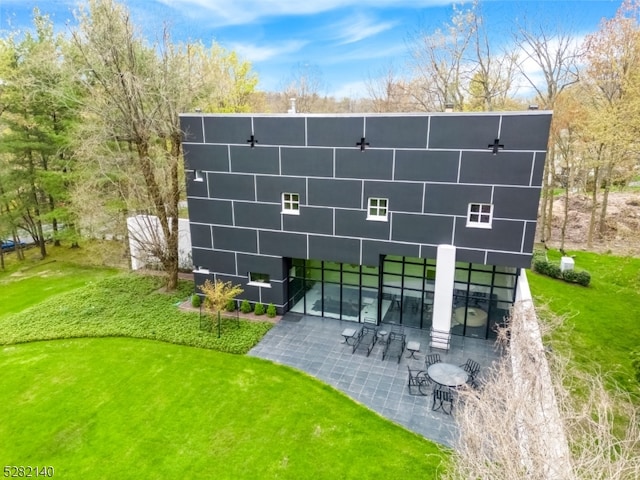 rear view of property with a patio and a yard