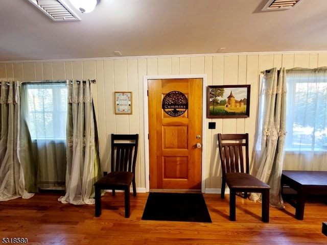 living area featuring hardwood / wood-style floors and crown molding