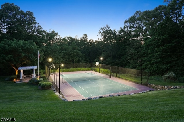 view of tennis court featuring a lawn