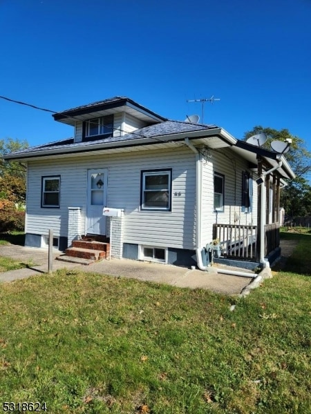 rear view of property featuring a yard