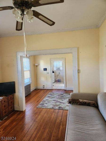 entrance foyer with ceiling fan, ornamental molding, dark wood-type flooring, and radiator heating unit