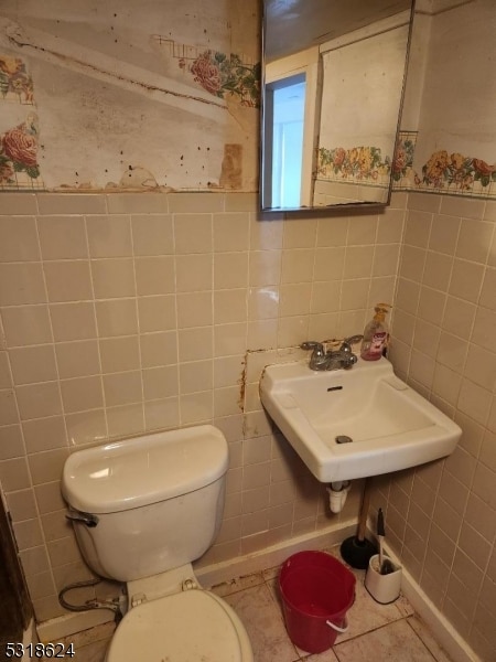 bathroom with tile walls, tile patterned flooring, and toilet