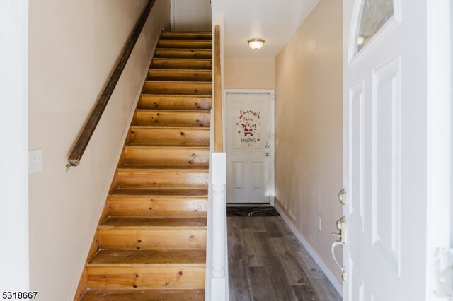 stairs with hardwood / wood-style floors and rustic walls