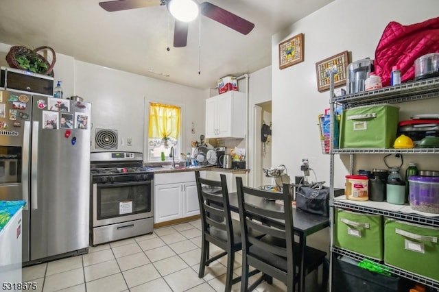 kitchen with sink, light tile patterned floors, ceiling fan, white cabinetry, and appliances with stainless steel finishes