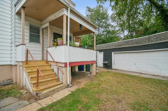 wooden deck featuring a garage, a yard, and an outdoor structure