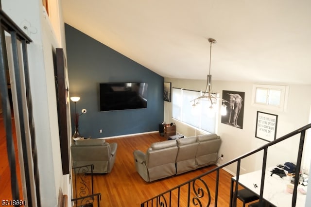 living room featuring a notable chandelier, lofted ceiling, and hardwood / wood-style floors